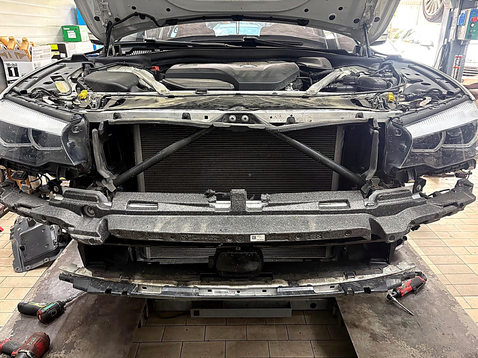 앞 범퍼와 그릴을 떼어 낸 BMW 520i 정면, 라디에이터가 드러난 모습