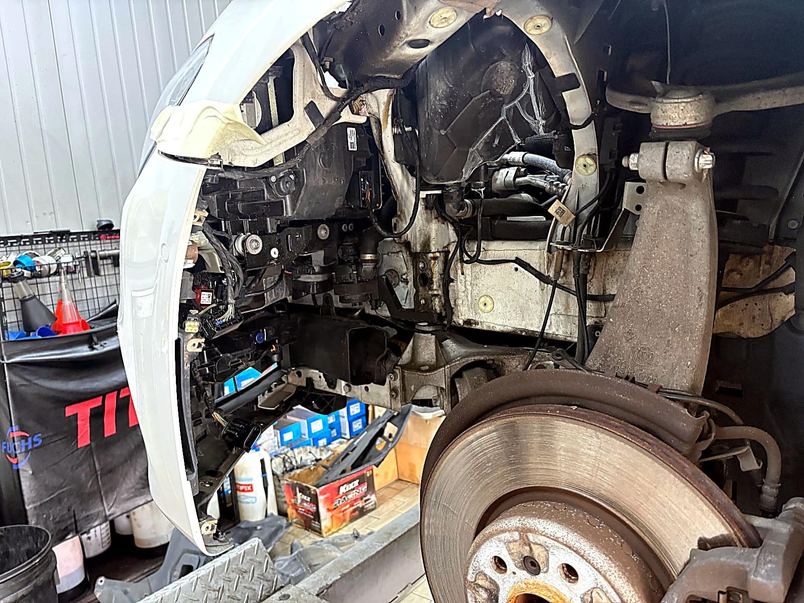 BMW 520i 앞 범퍼를 분리하는 중 드러난 휠하우스 안쪽과 범퍼 고정부