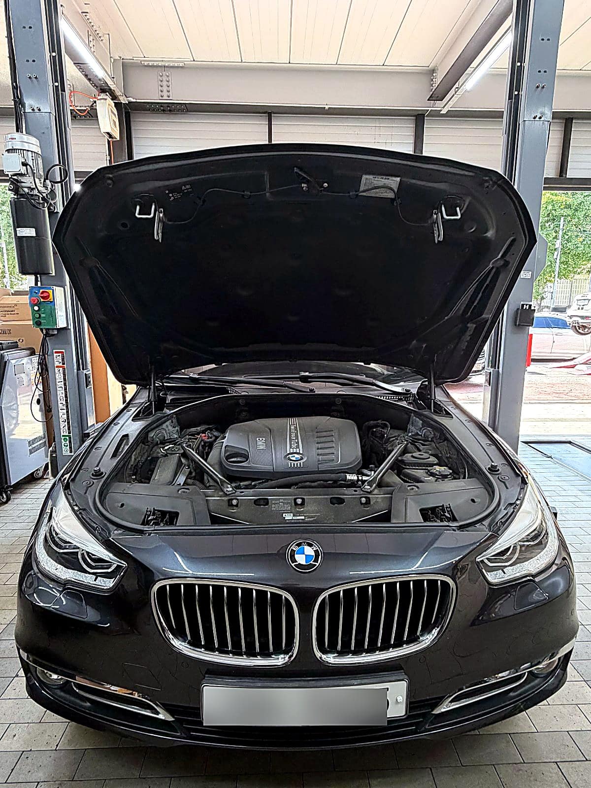 본넷을 열고 엔진룸을 확인 중인 BMW 530d GT