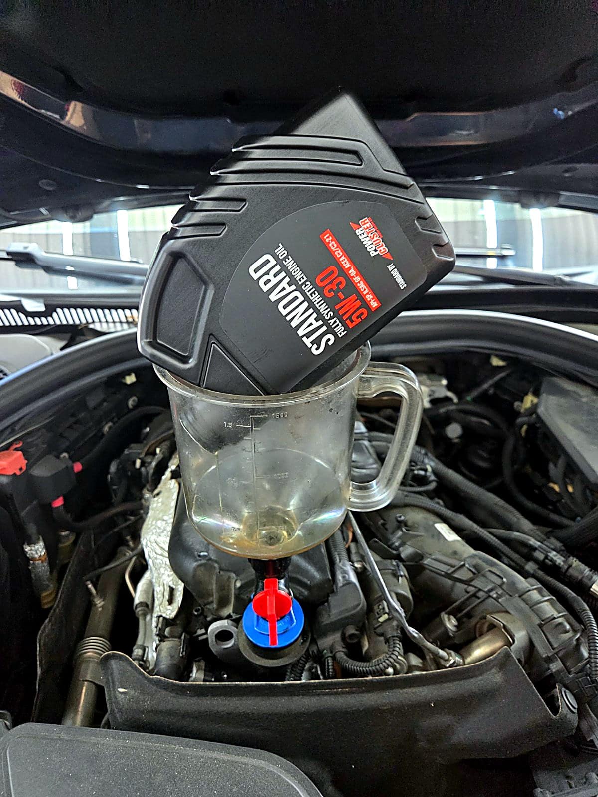 BMW M550d 엔진에 새 엔진오일을 주입하는 모습