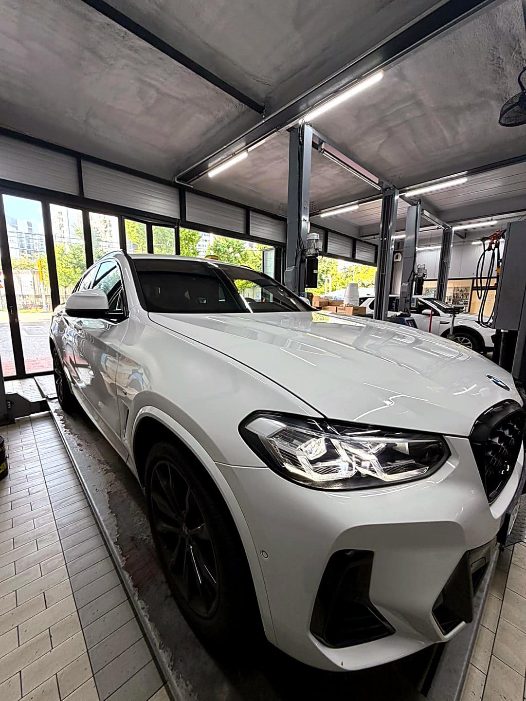 BMW X4 xDrive20i 측면, 신차 상태의 흰색 차체