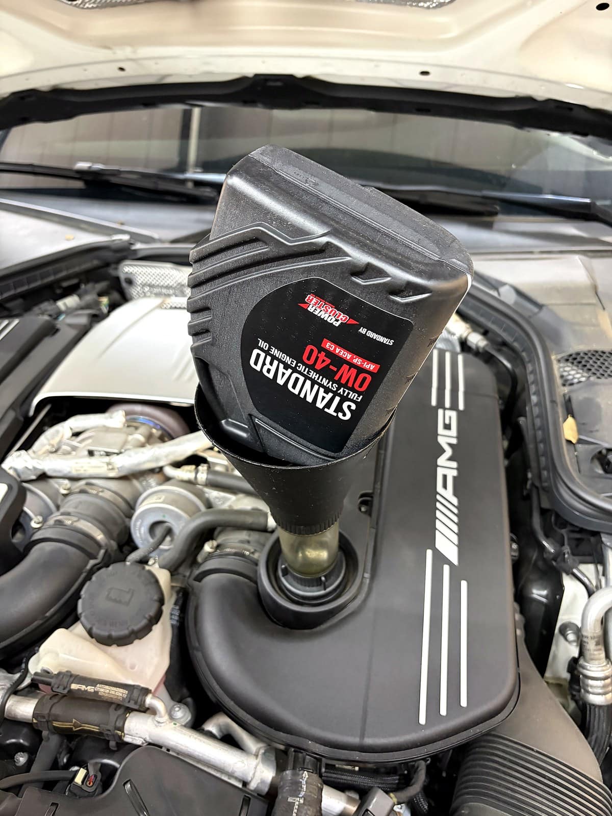 벤츠 AMG C63 S 엔진에 0W-40 완전합성유를 주입하는 모습