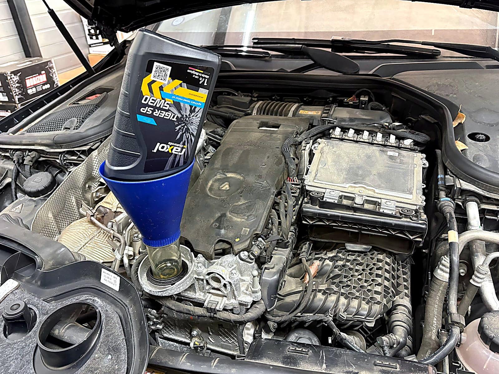 벤츠 CLS450 엔진에 5W-30 새 엔진오일을 깔때기로 주입하는 모습
