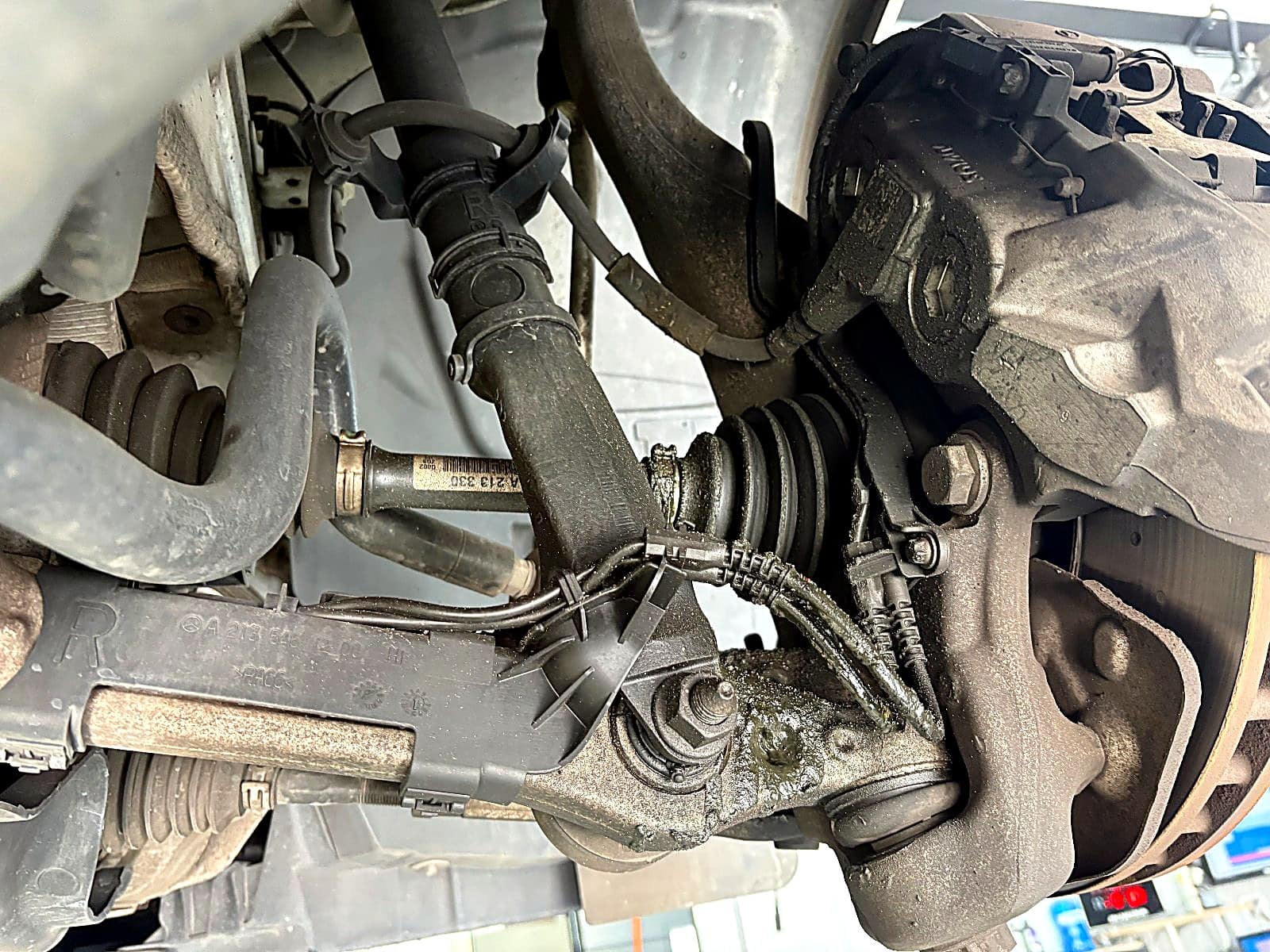 벤츠 E300 오른쪽 앞 등속조인트 부트에서 새어 나온 그리스가 너클과 로워암에 번진 모습