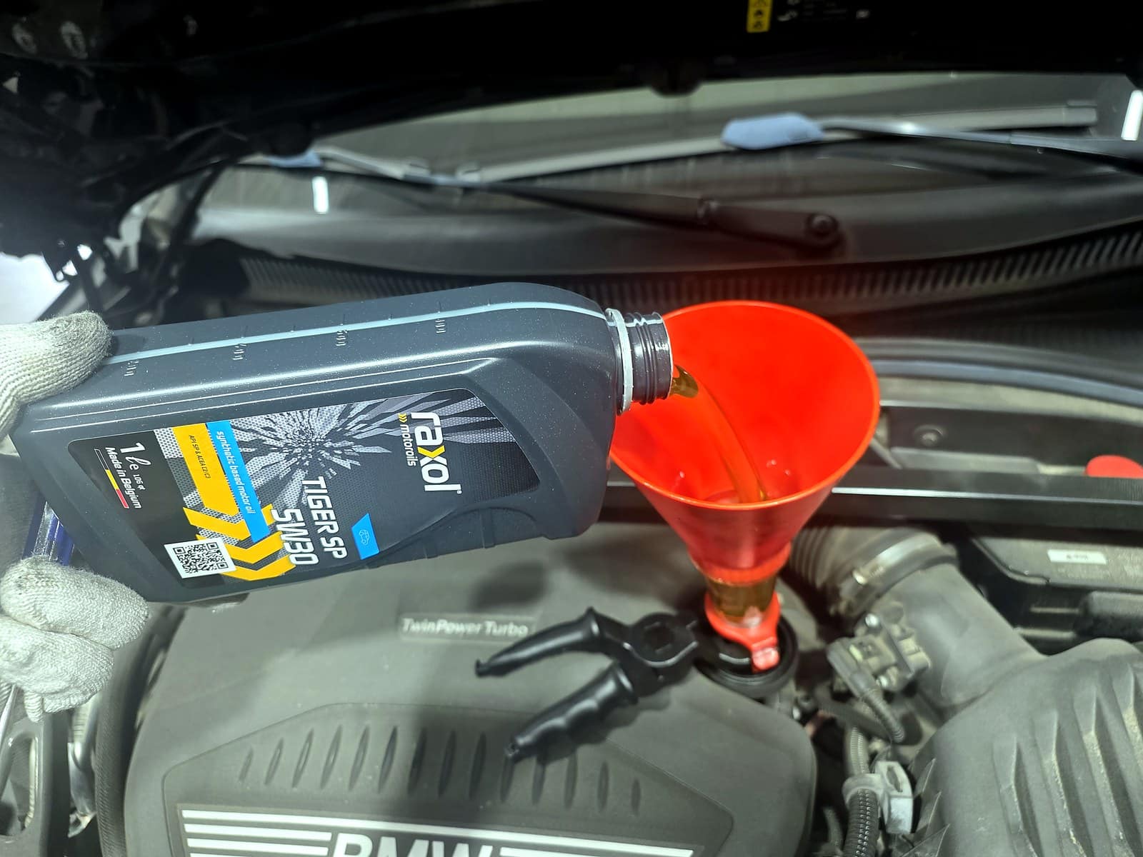BMW 218d에 새 엔진오일을 주입하는 모습